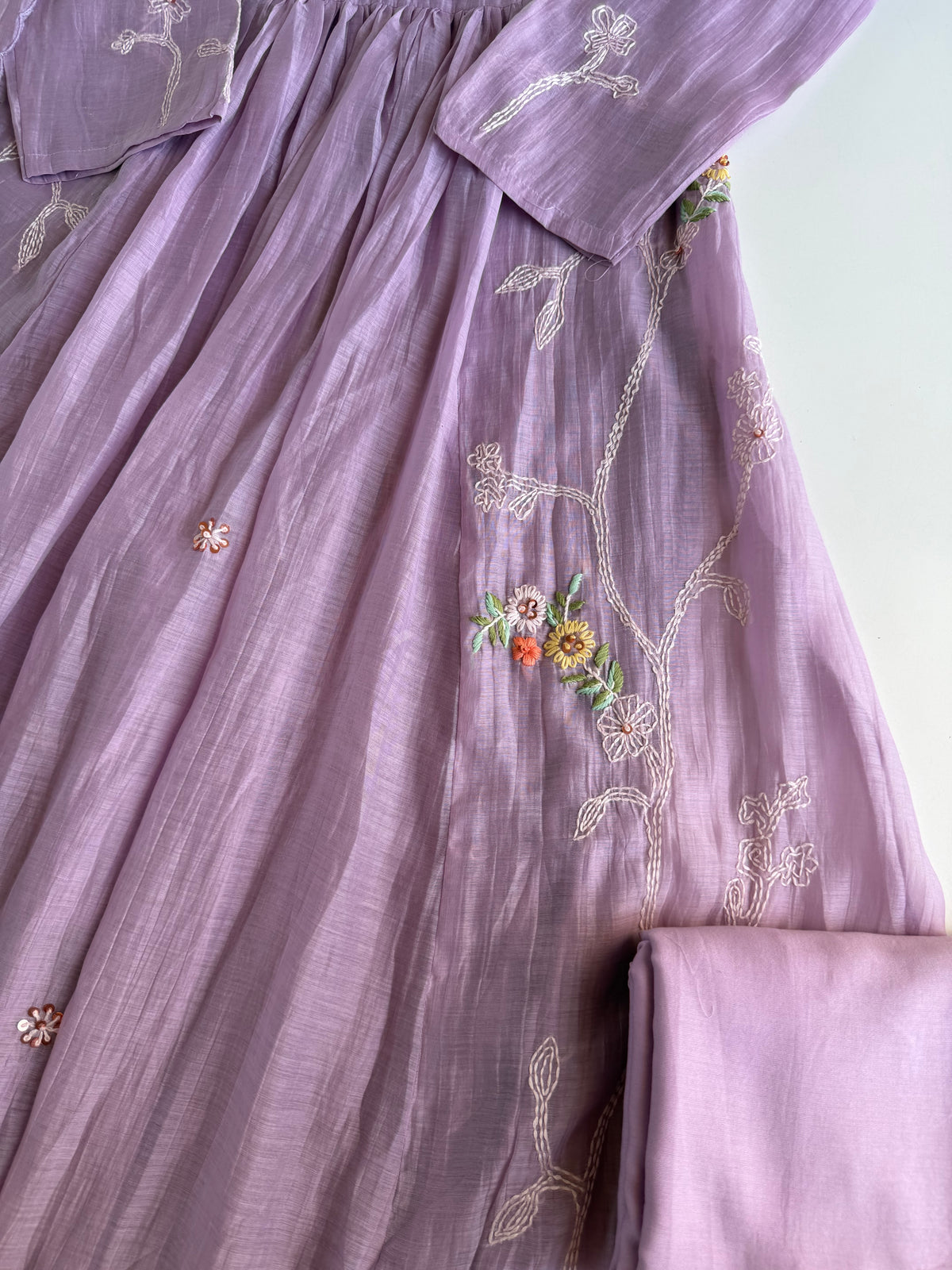 Purple embroidered dress with floral patterns on a light background